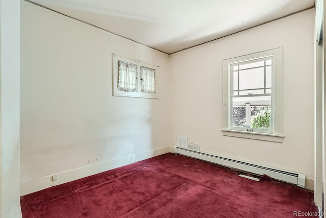 unfurnished room featuring a baseboard heating unit and carpet