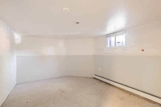 basement with a baseboard heating unit and carpet