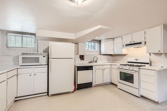 kitchen featuring a wealth of natural light, sink, white cabinetry, and white appliances