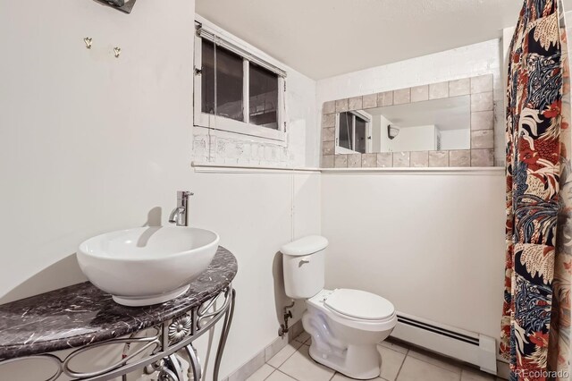 bathroom featuring vanity, toilet, a baseboard heating unit, and tile patterned flooring