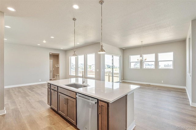 21022 E 63rd Dr, Aurora, CO 80019 - kitchen with sink, decorative light fixtures, stainless steel dishwasher, a kitchen island with sink, and light hardwood / wood-style floors