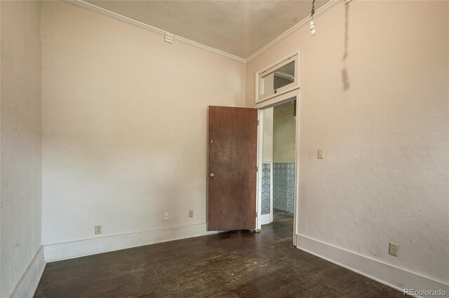 empty room with ornamental molding and dark wood-type flooring