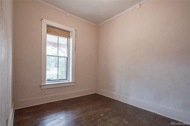 spare room with ornamental molding and dark hardwood / wood-style floors