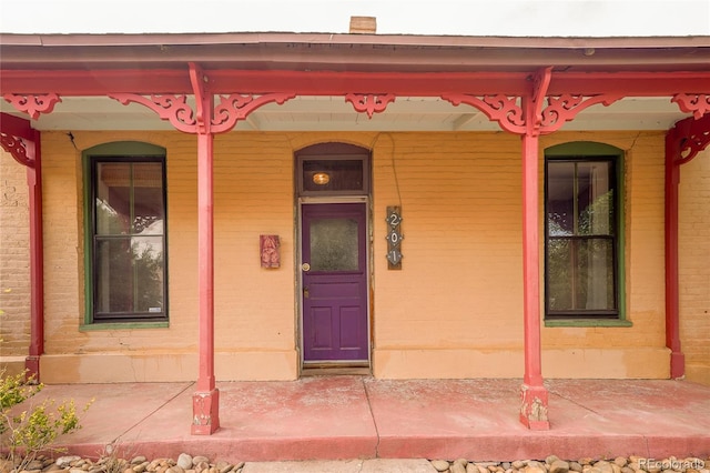 view of exterior entry featuring covered porch