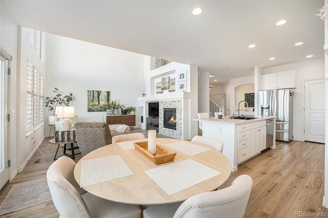 dining space featuring a fireplace, light hardwood / wood-style flooring, and sink