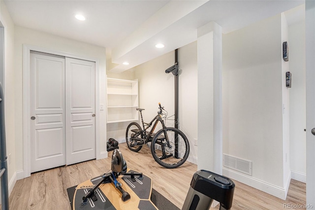 workout room with light hardwood / wood-style flooring