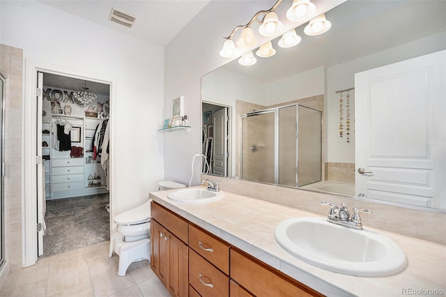 bathroom featuring walk in shower, vanity, tile patterned flooring, and toilet