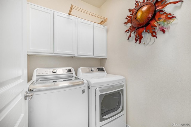 laundry area featuring washing machine and dryer and cabinets