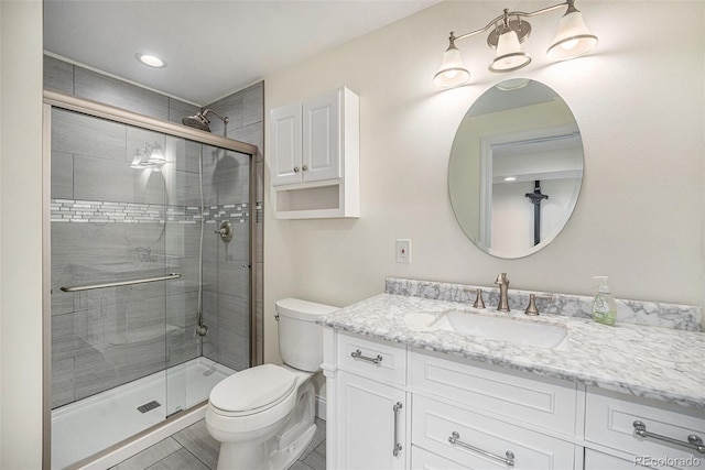 bathroom with toilet, vanity, an enclosed shower, and tile patterned floors