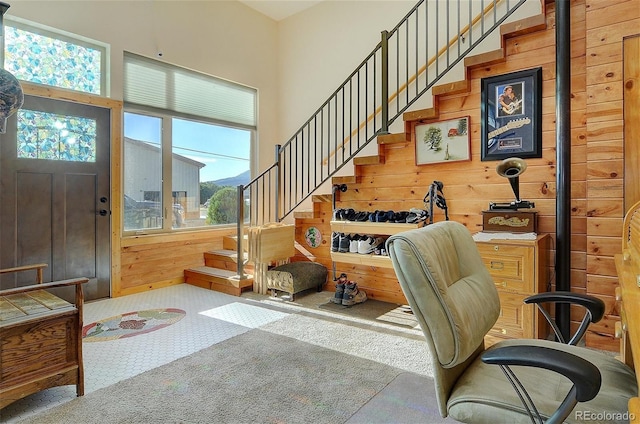 foyer with a high ceiling, light carpet, and a healthy amount of sunlight