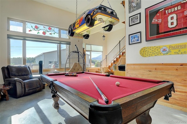 game room with billiards, a towering ceiling, and concrete flooring