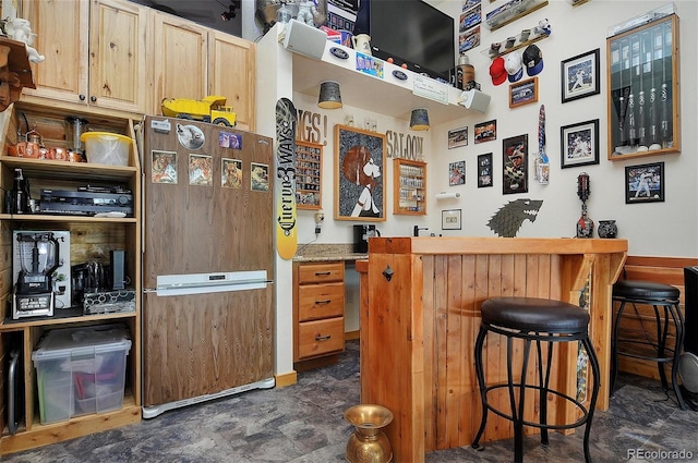 bar with light brown cabinetry