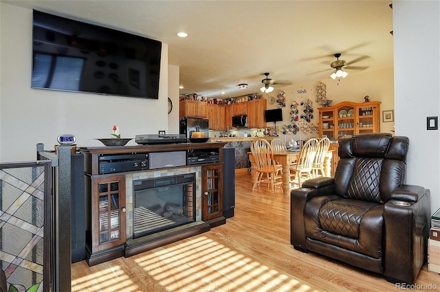 living room featuring light hardwood / wood-style flooring and ceiling fan