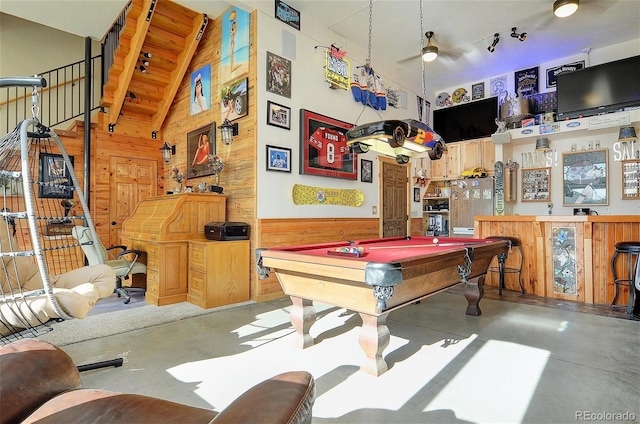 rec room featuring billiards, wood walls, ceiling fan, and concrete flooring