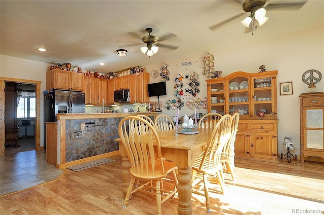 dining area featuring light wood-type flooring and ceiling fan