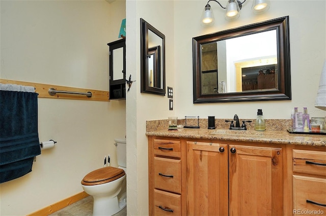 bathroom featuring tile patterned flooring, toilet, and vanity