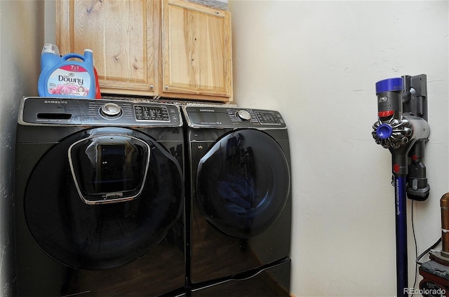 laundry room featuring washing machine and dryer and cabinets