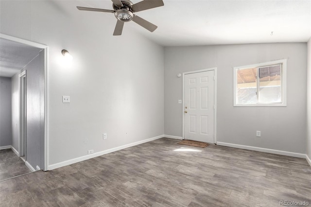 spare room with lofted ceiling, baseboards, and wood finished floors