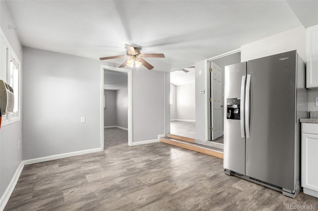 kitchen with baseboards, white cabinets, stainless steel fridge with ice dispenser, and wood finished floors