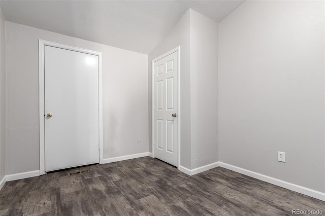 unfurnished bedroom with wood finished floors, visible vents, and baseboards