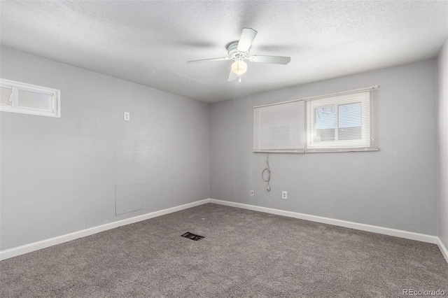 unfurnished room featuring visible vents, baseboards, a ceiling fan, a textured ceiling, and carpet flooring