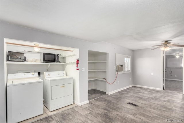 clothes washing area featuring laundry area, visible vents, baseboards, light wood finished floors, and washer and clothes dryer