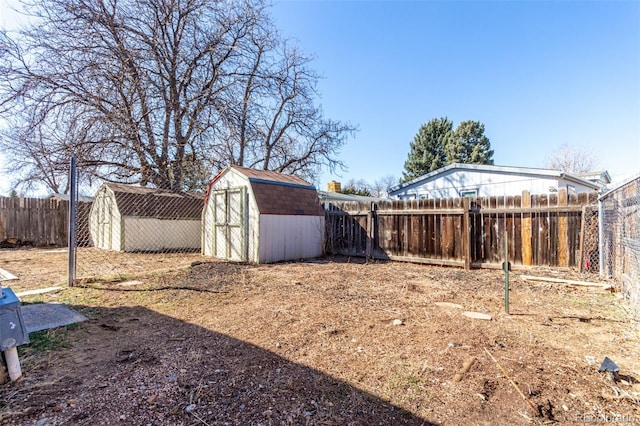 view of yard with an outbuilding, a fenced backyard, and a shed