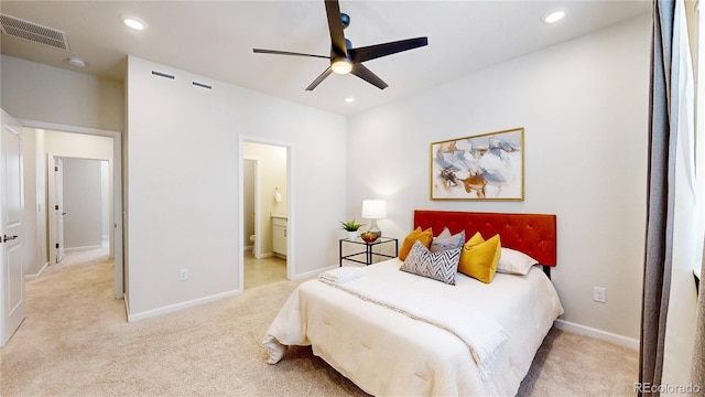 carpeted bedroom with ensuite bath and ceiling fan