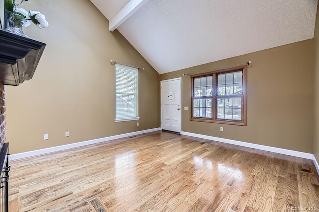 foyer with light wood-style floors, beam ceiling, visible vents, and baseboards