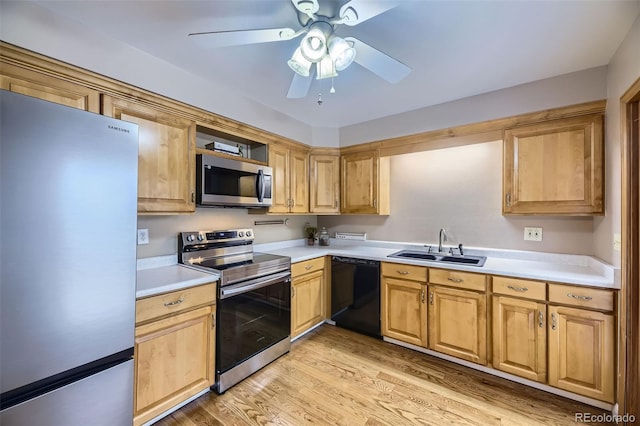 kitchen featuring ceiling fan, a sink, light countertops, appliances with stainless steel finishes, and light wood finished floors