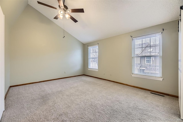 carpeted spare room featuring baseboards, visible vents, and ceiling fan