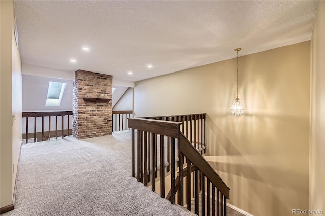 corridor featuring a textured ceiling, recessed lighting, carpet floors, an upstairs landing, and baseboards