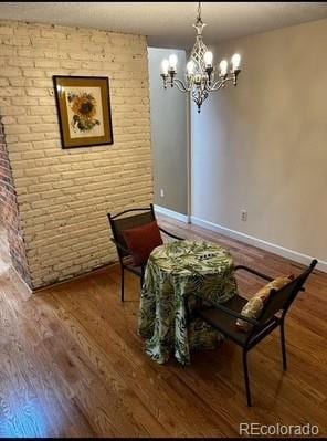 7721 S Curtice Way Unit B, Littleton, CO 80120 - living area featuring a chandelier, wood finished floors, baseboards, and brick wall