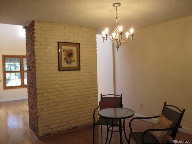 7721 S Curtice Way Unit B, Littleton, CO 80120 - dining area with a textured ceiling, wood finished floors, and a chandelier