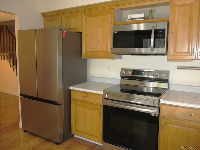 7721 S Curtice Way Unit B, Littleton, CO 80120 - kitchen featuring appliances with stainless steel finishes, light countertops, light wood-style flooring, and light brown cabinetry