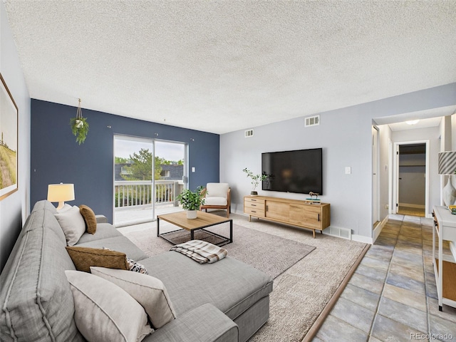 190 E Highline Cir Unit 302, Centennial, CO 80122 - living room featuring a textured ceiling, baseboards, and stone finish floors