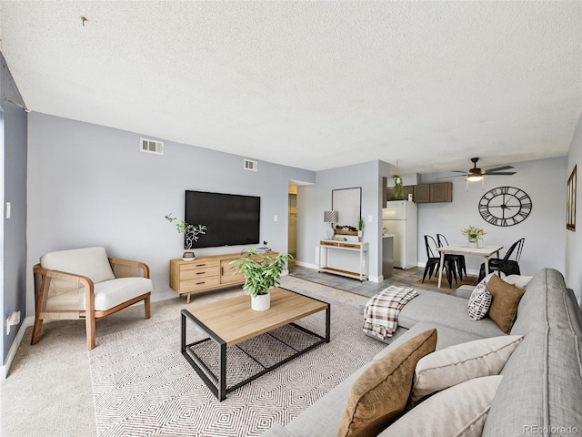 190 E Highline Cir Unit 302, Centennial, CO 80122 - living room featuring a ceiling fan, a textured ceiling, light colored carpet, and baseboards