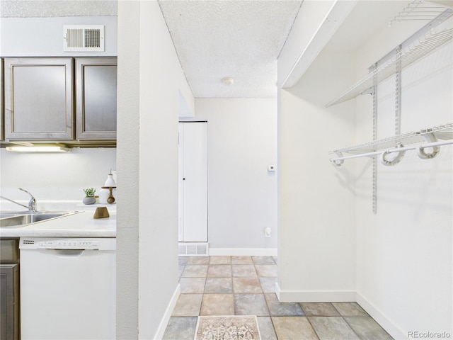 190 E Highline Cir Unit 302, Centennial, CO 80122 - kitchen with dishwasher, a sink, a textured ceiling, baseboards, and light countertops