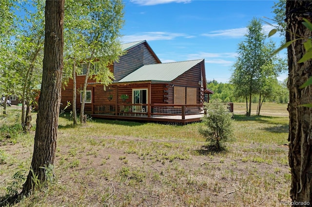 back of house featuring a yard and a wooden deck