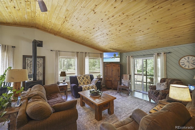 living room featuring plenty of natural light, wooden ceiling, and a wood stove