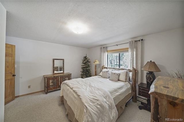 bedroom featuring light carpet and a textured ceiling