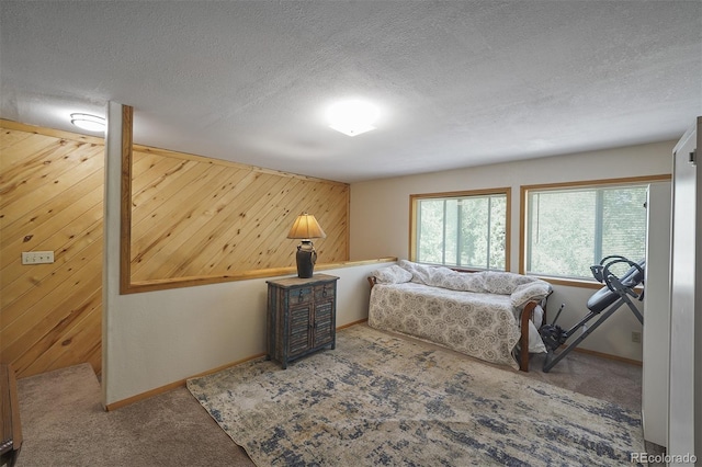 bedroom with wooden walls and a textured ceiling