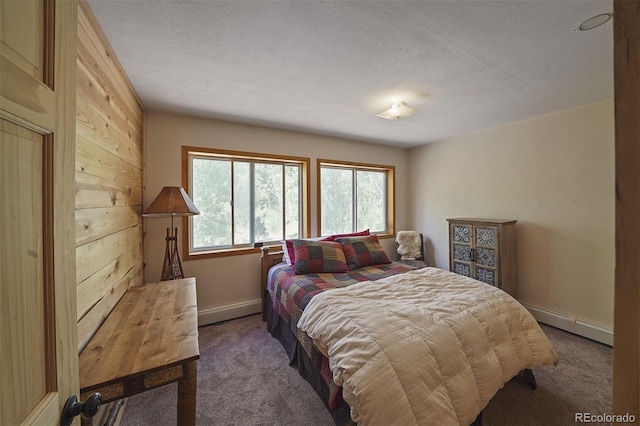 bedroom featuring carpet, a baseboard heating unit, and a textured ceiling