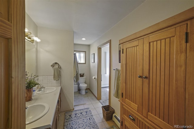 bathroom featuring tile patterned floors, vanity, toilet, and a baseboard heating unit