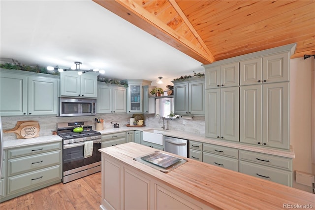 kitchen with sink, wooden counters, light hardwood / wood-style flooring, stainless steel appliances, and decorative backsplash