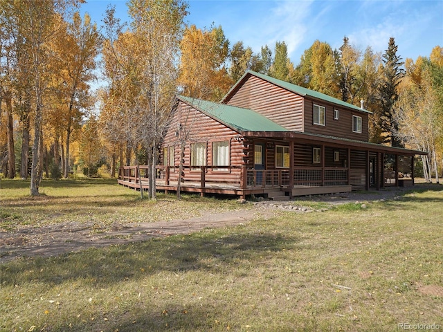 rear view of property featuring a wooden deck and a lawn