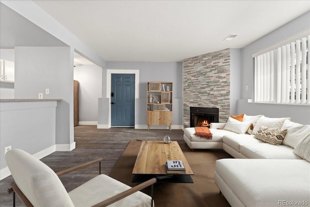 living room featuring dark wood-type flooring and a fireplace