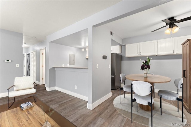 dining room featuring hardwood / wood-style flooring, electric panel, and ceiling fan