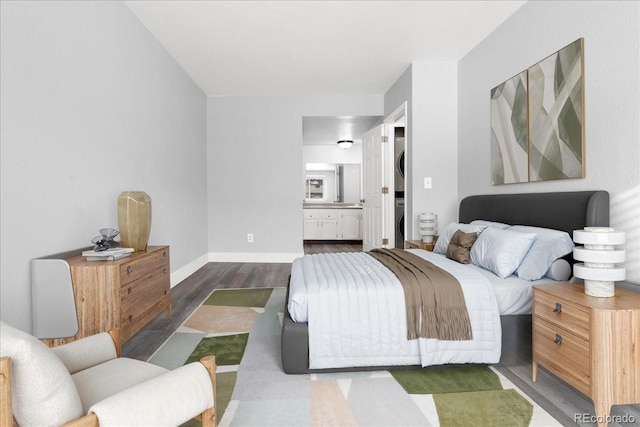 bedroom with dark hardwood / wood-style flooring and ensuite bathroom