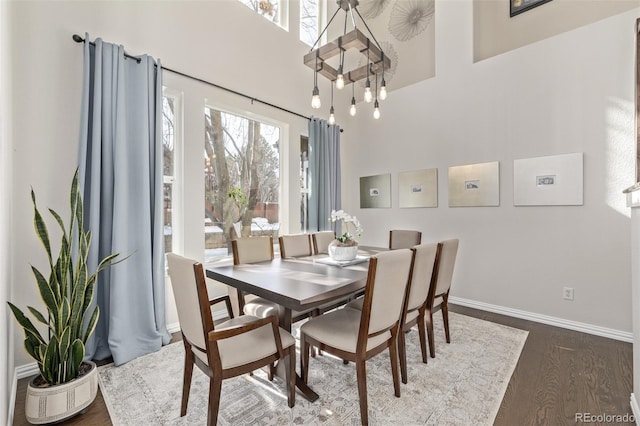 dining space with baseboards and dark wood finished floors